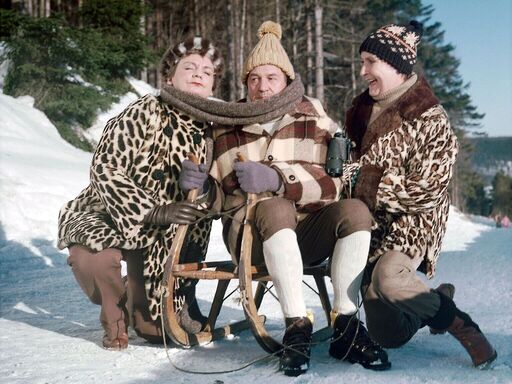Martha (Ingeborg Krabbe), Herr Martin (Herbert Köfer) und Anna (Ursula Braun) (v.l.n.r.) haben ihren Spaß beim Schlittenfahren | Bildquelle: DRA/Hans-Ulrich Raschke Zwei Frauen in Leopardenmantel posieren neben einem Mann, der auf einem Schlitten sitzt